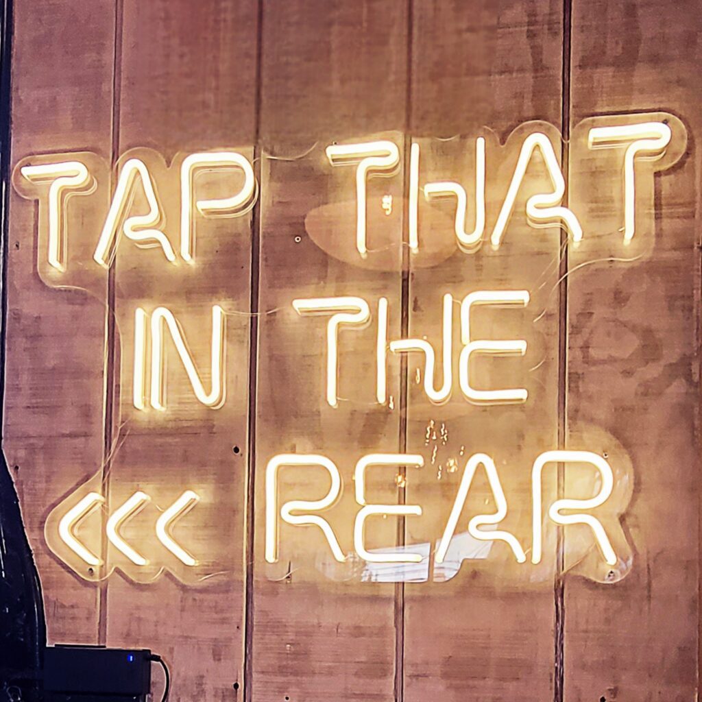 A light sign that says Tap that in the rear